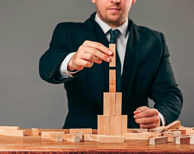 Imagen de ejecutivo construyento una torre de bloques de madera